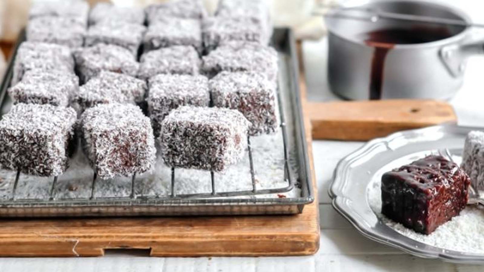 Classic Australian lamington sponge cake cubes coated in chocolate sauce and rolled in coconut flakes.