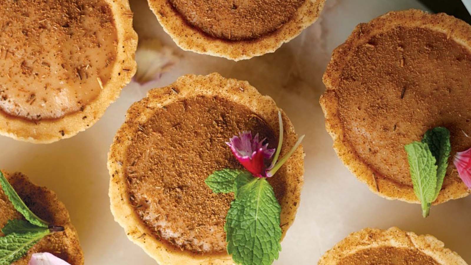 A traditional baked South African milk tart dusted lightly with cinnamon powder.