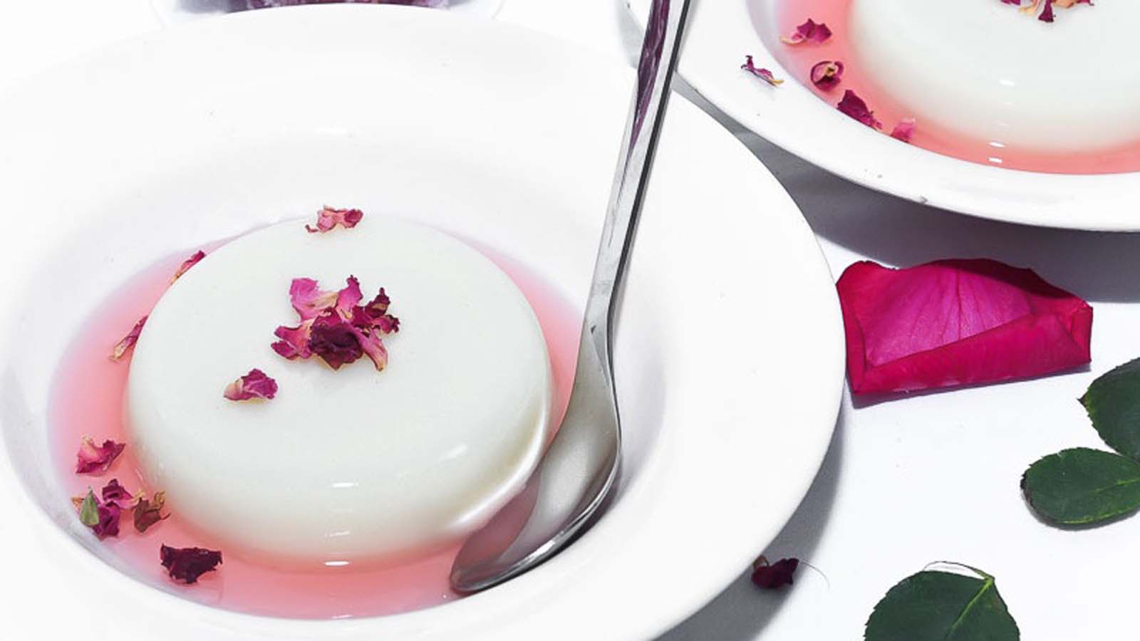 Velvety smooth vanilla panna cotta unmolded on a plate with fresh berry coulis.