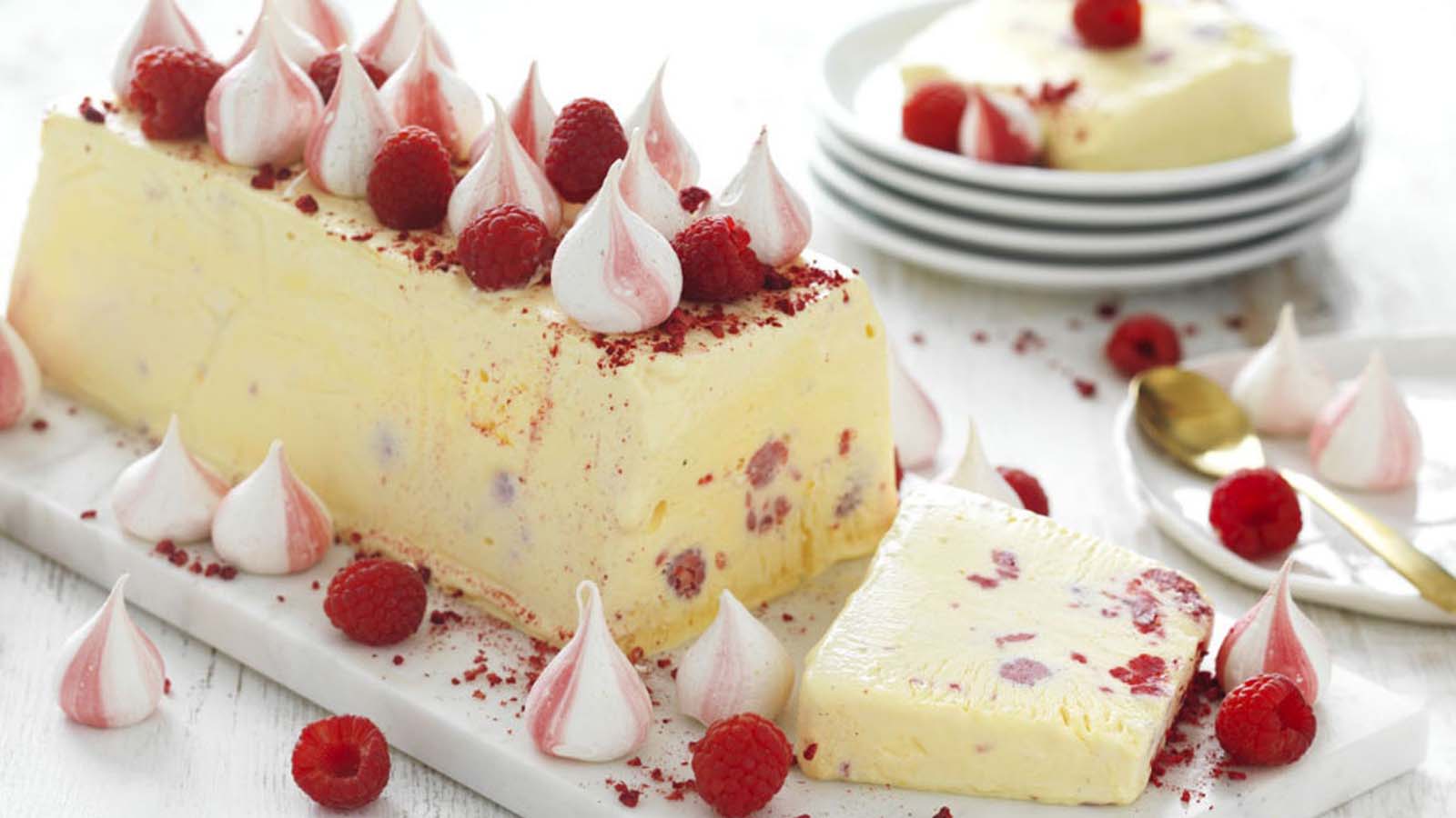An elegant white chocolate and nougat semifreddo frozen dessert sliced on a platter.