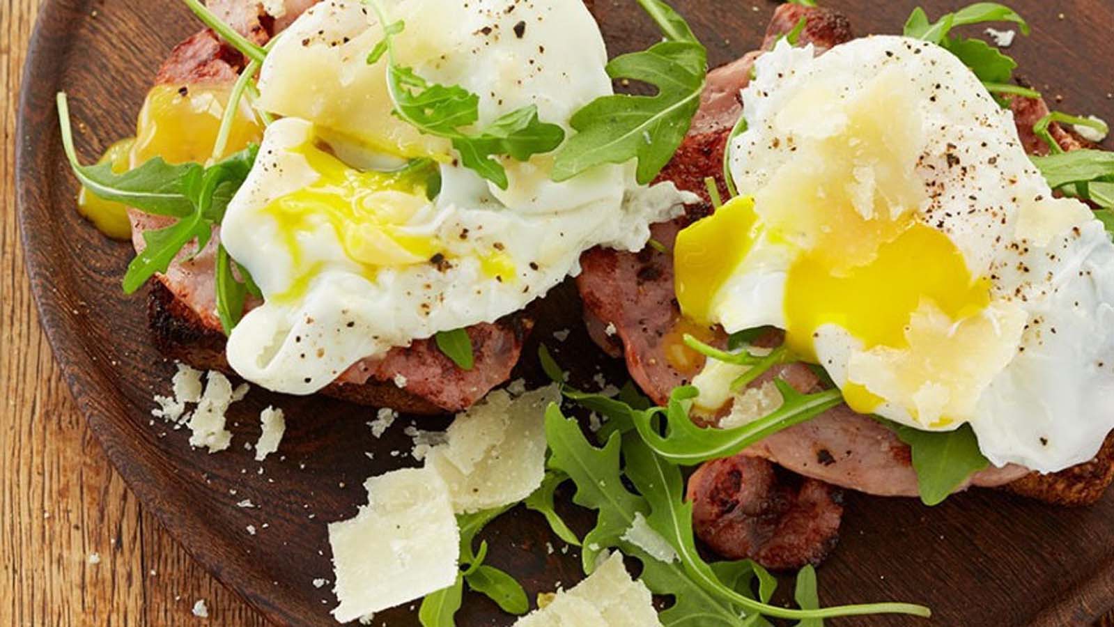 A buttery split croissant filled with crispy bacon, melted mozzarella, and a poached egg.
