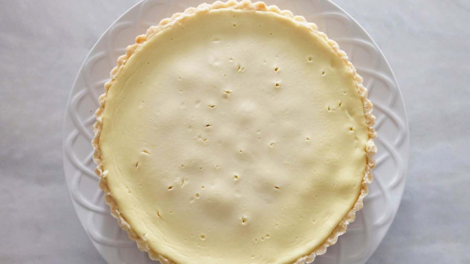 A traditional baked creamy Greek yogurt tart dessert showing a clean smooth surface.