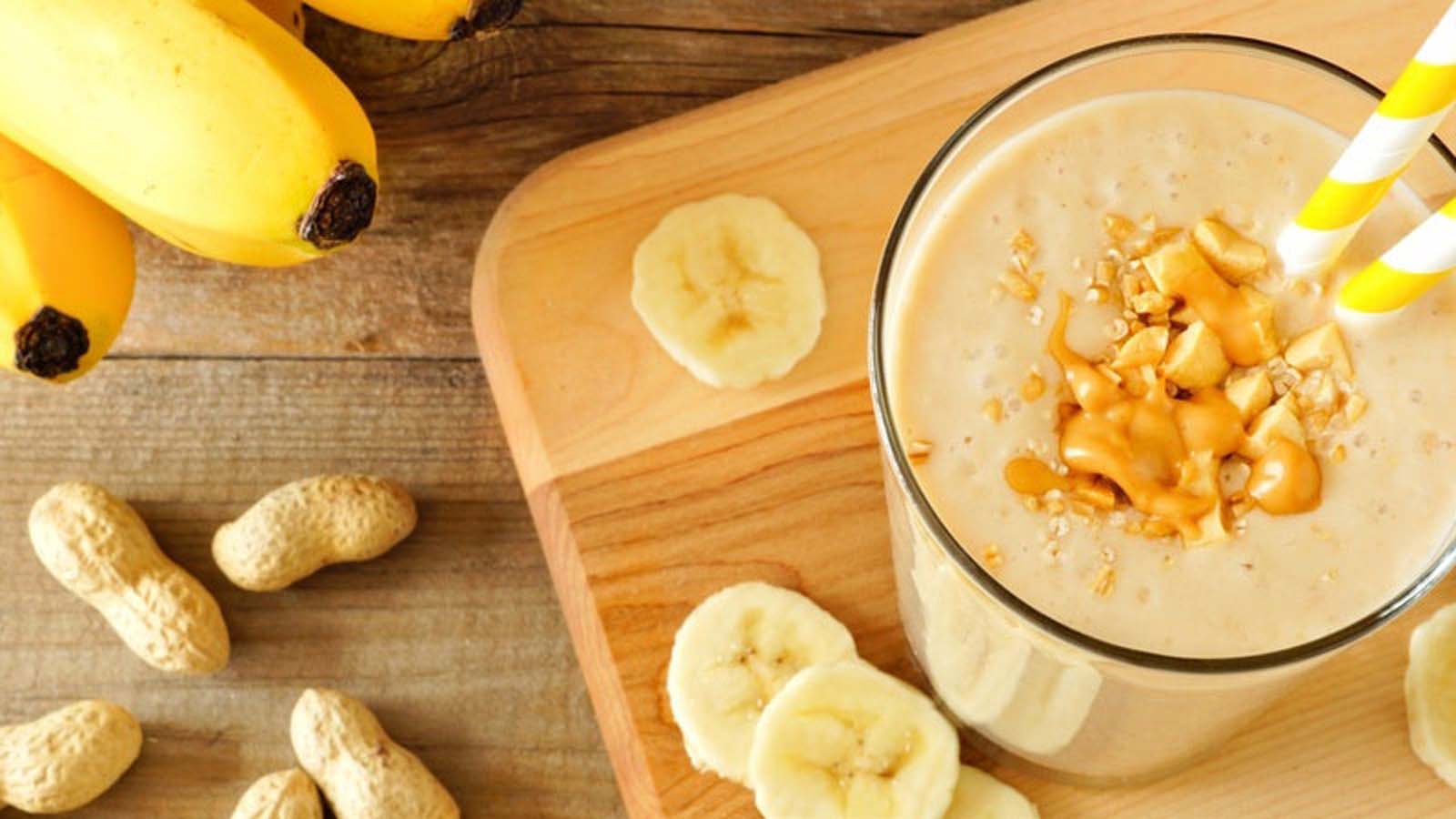 A thick, healthy blended banana and peanut butter smoothie protein shake cup.