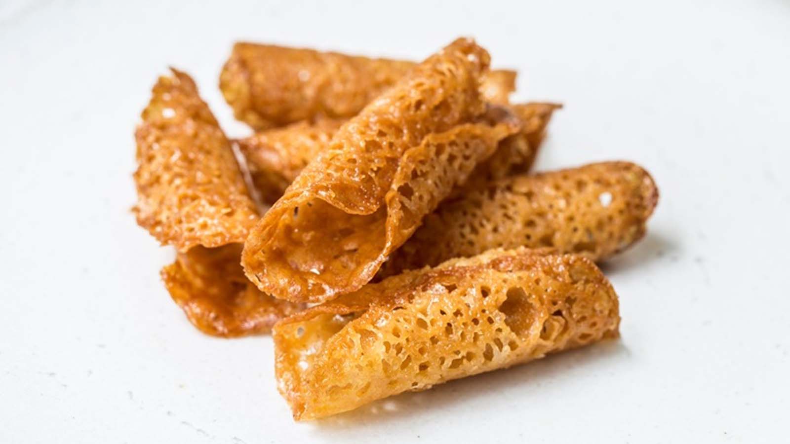 Crisp and golden lace-like brandy snaps rolled into delicate tubes.