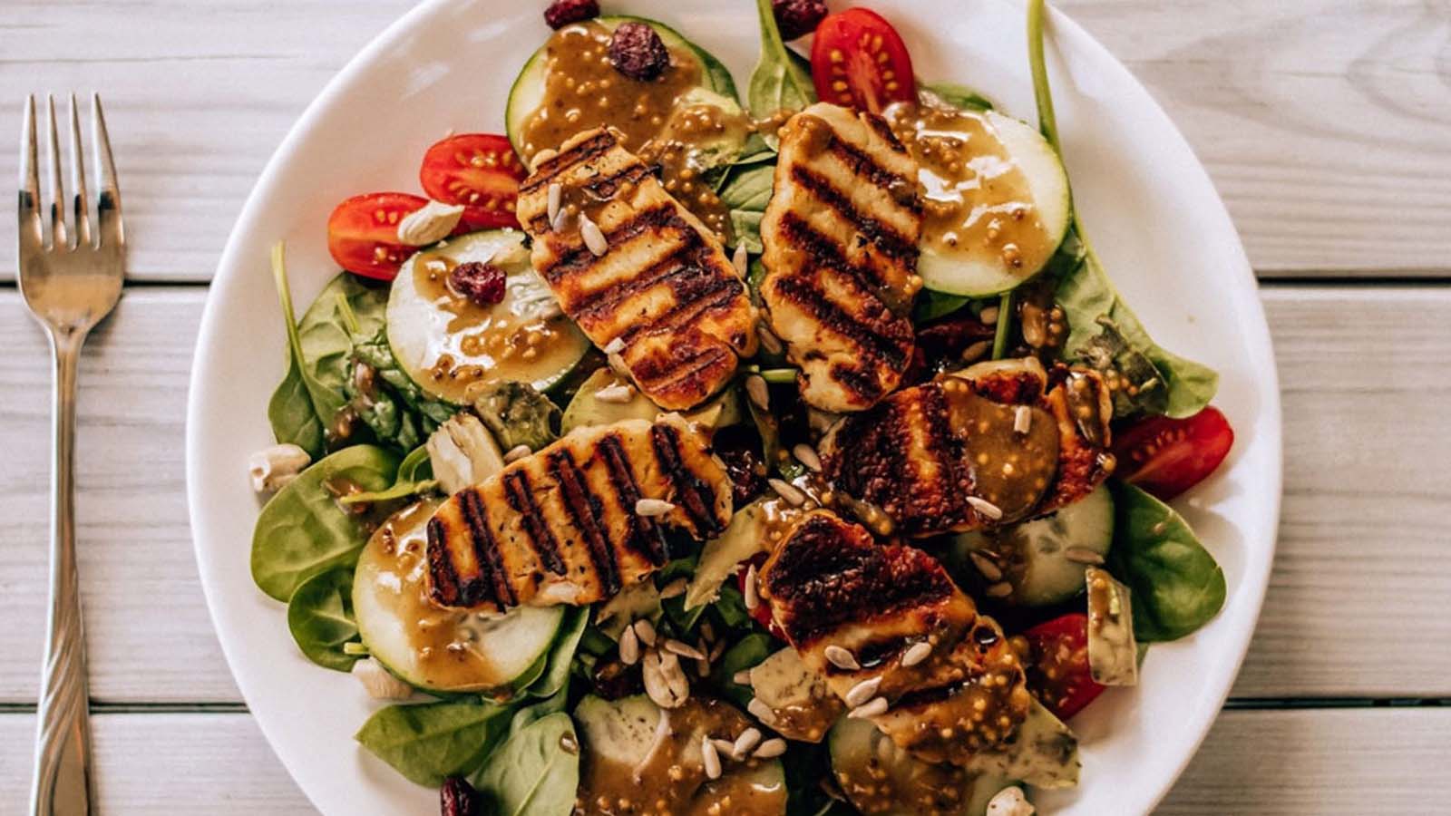 A fresh Cajun chicken salad with sliced spicy grilled chicken over garden greens.