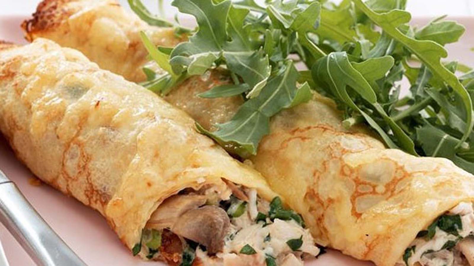 savoury pancakes filled with a creamy chicken mixture and rolled up tightly.