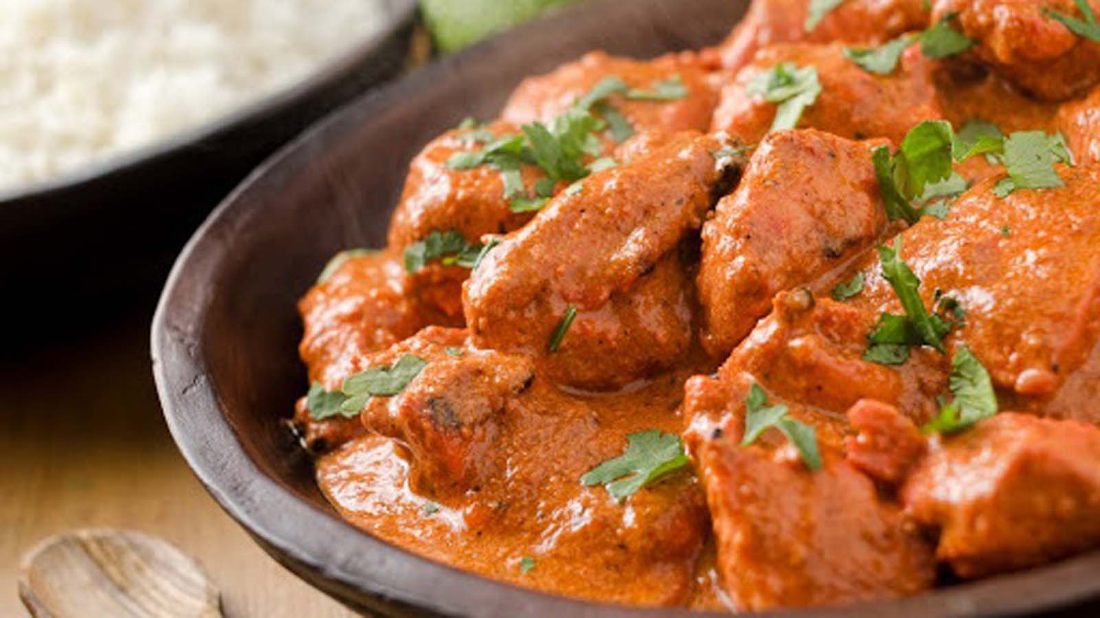 A popular bowl of creamy, orange spiced Indian chicken tikka masala curry chicken.