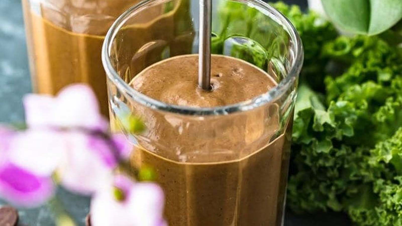 A rich and healthy dark chocolate detox smoothie inside a tall glass straw jar.