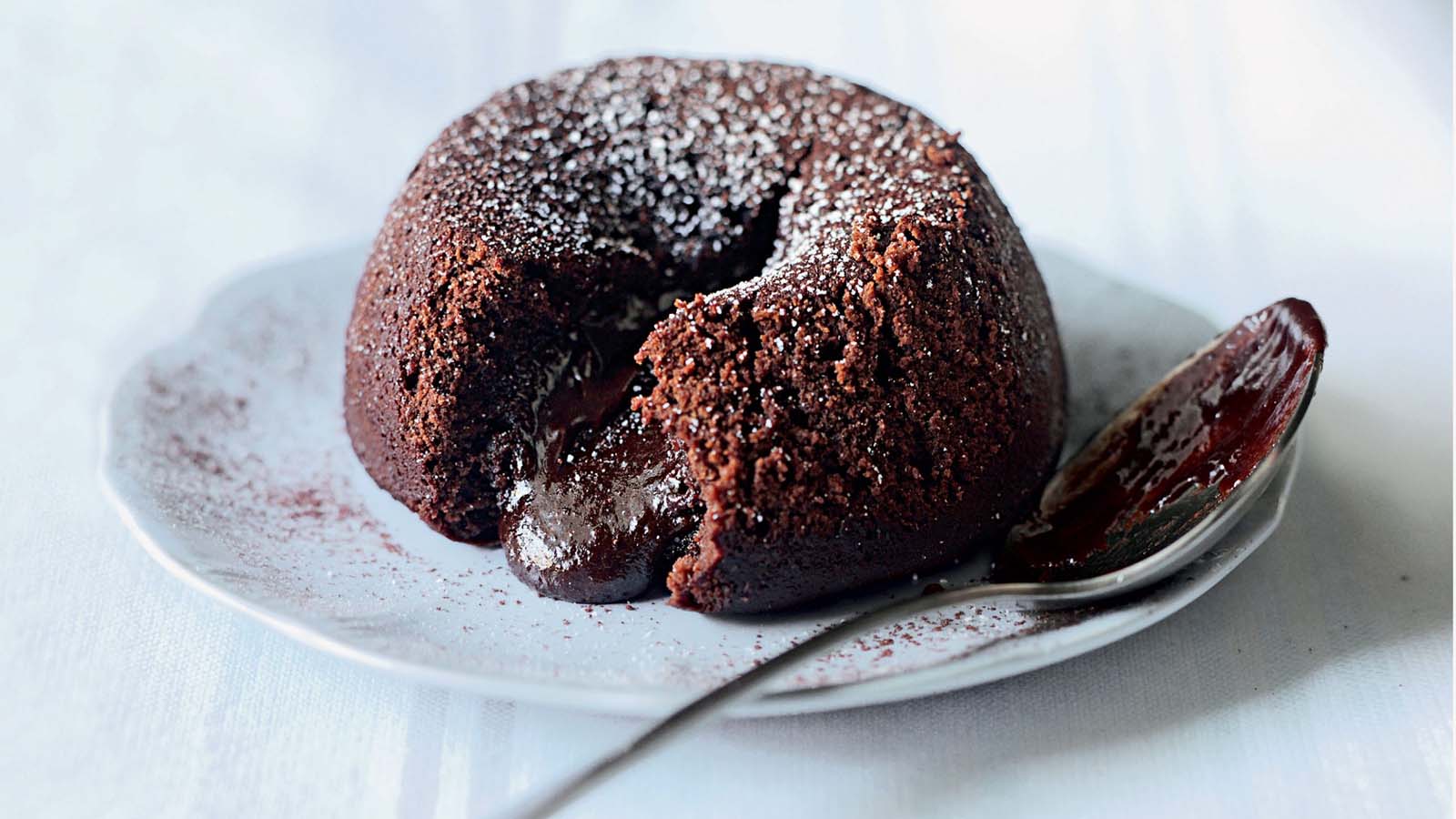 A rich chocolate fondant cake with a gooey, molten chocolate center flowing out.