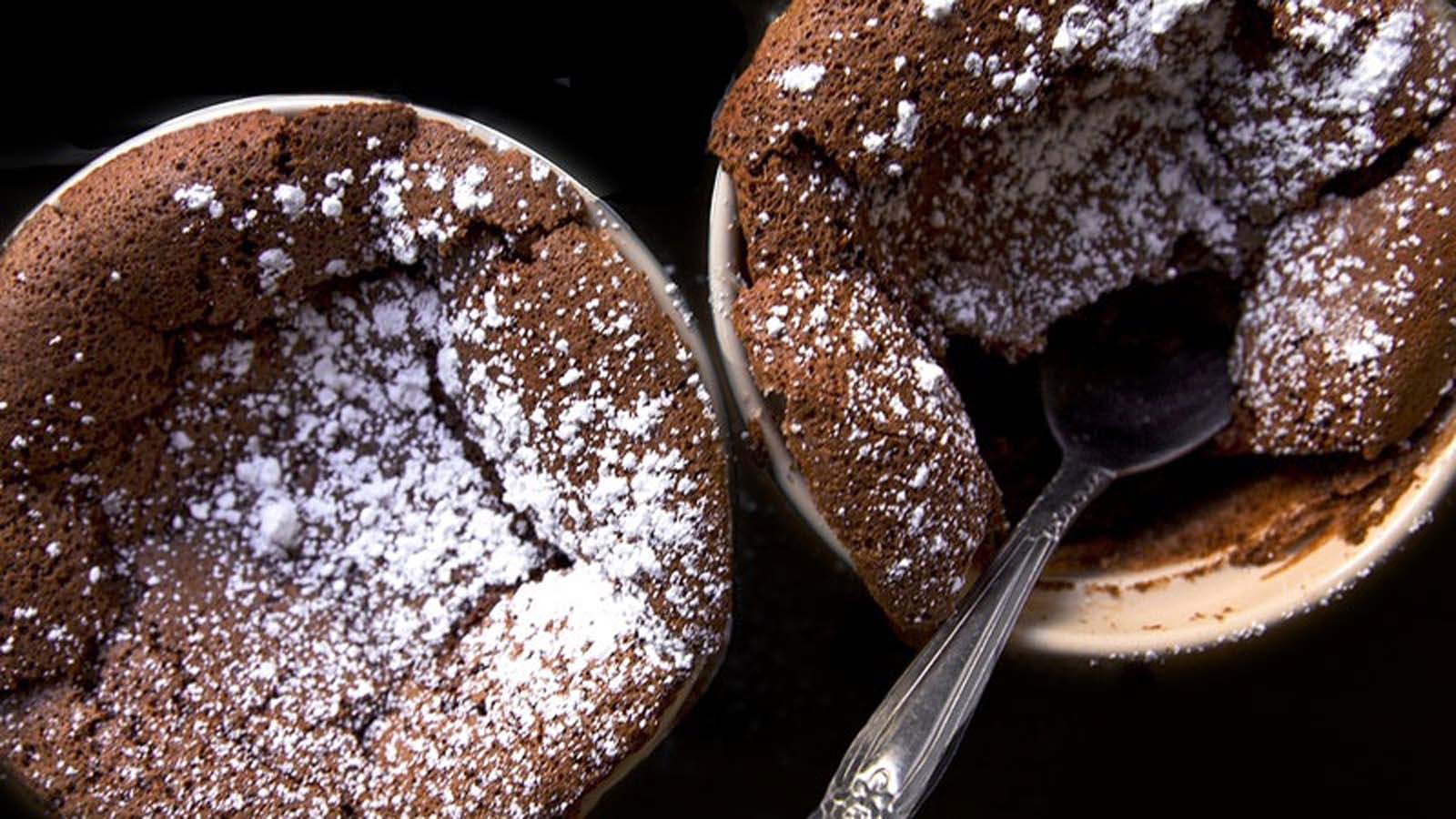 A perfectly risen, light and airy hot chocolate souffle dusted with powdered sugar.
