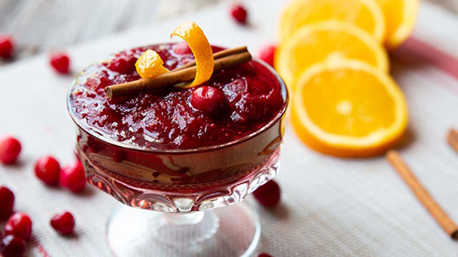A dish of bright red, sweet and tart homemade cranberry sauce condiment mix.