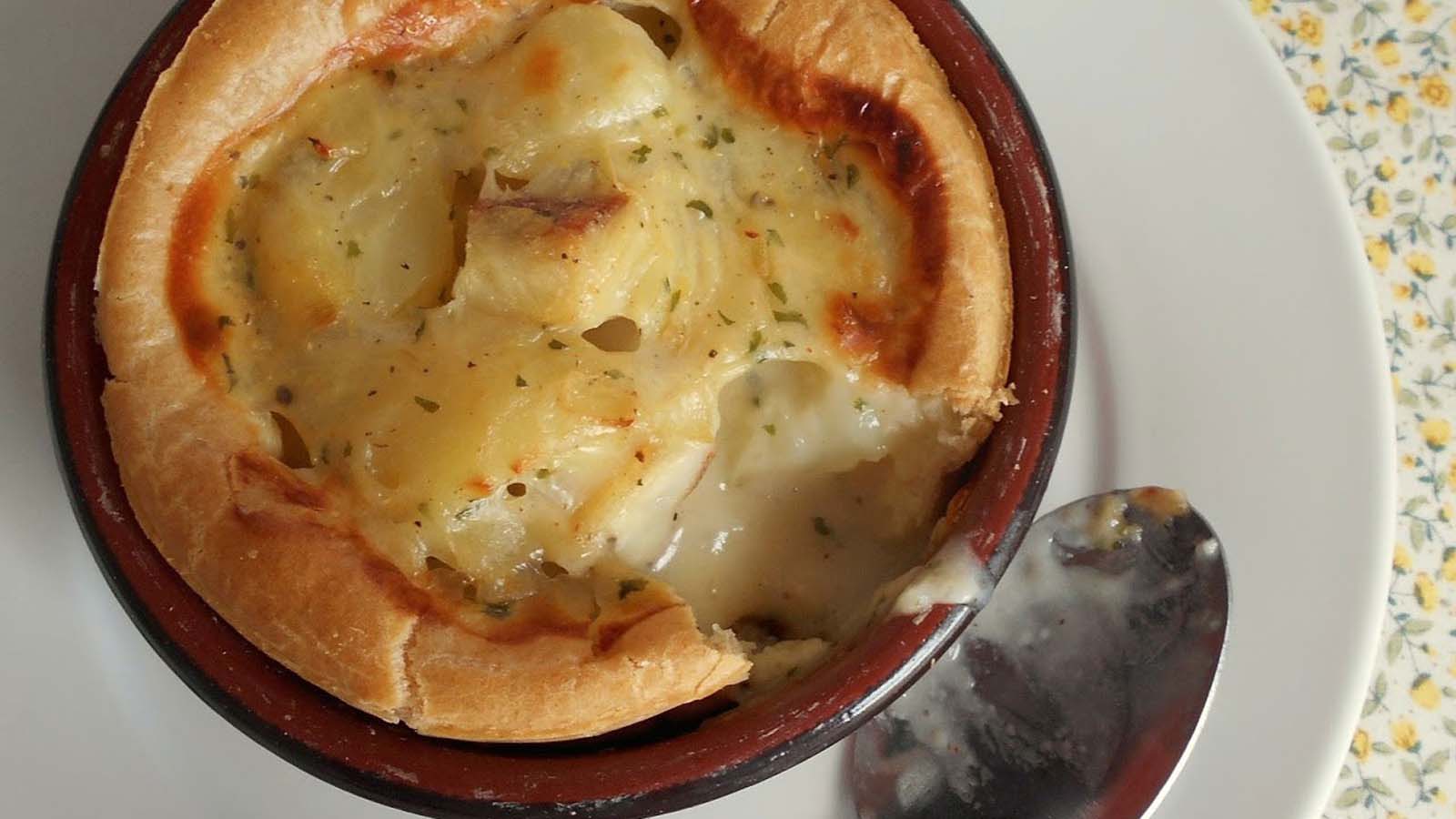 A rich creamy fish pie topped with a unique, airy choux pastry baked crust.
