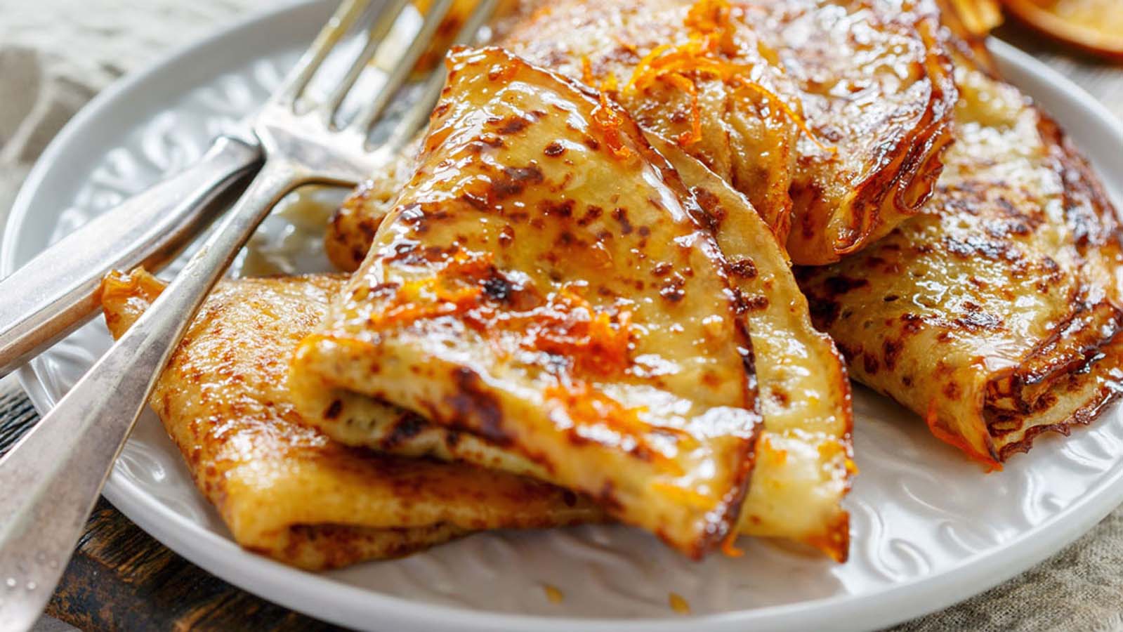 Thin French crepes suzette dessert swimming in a flaming orange butter and Grand Marnier sauce.