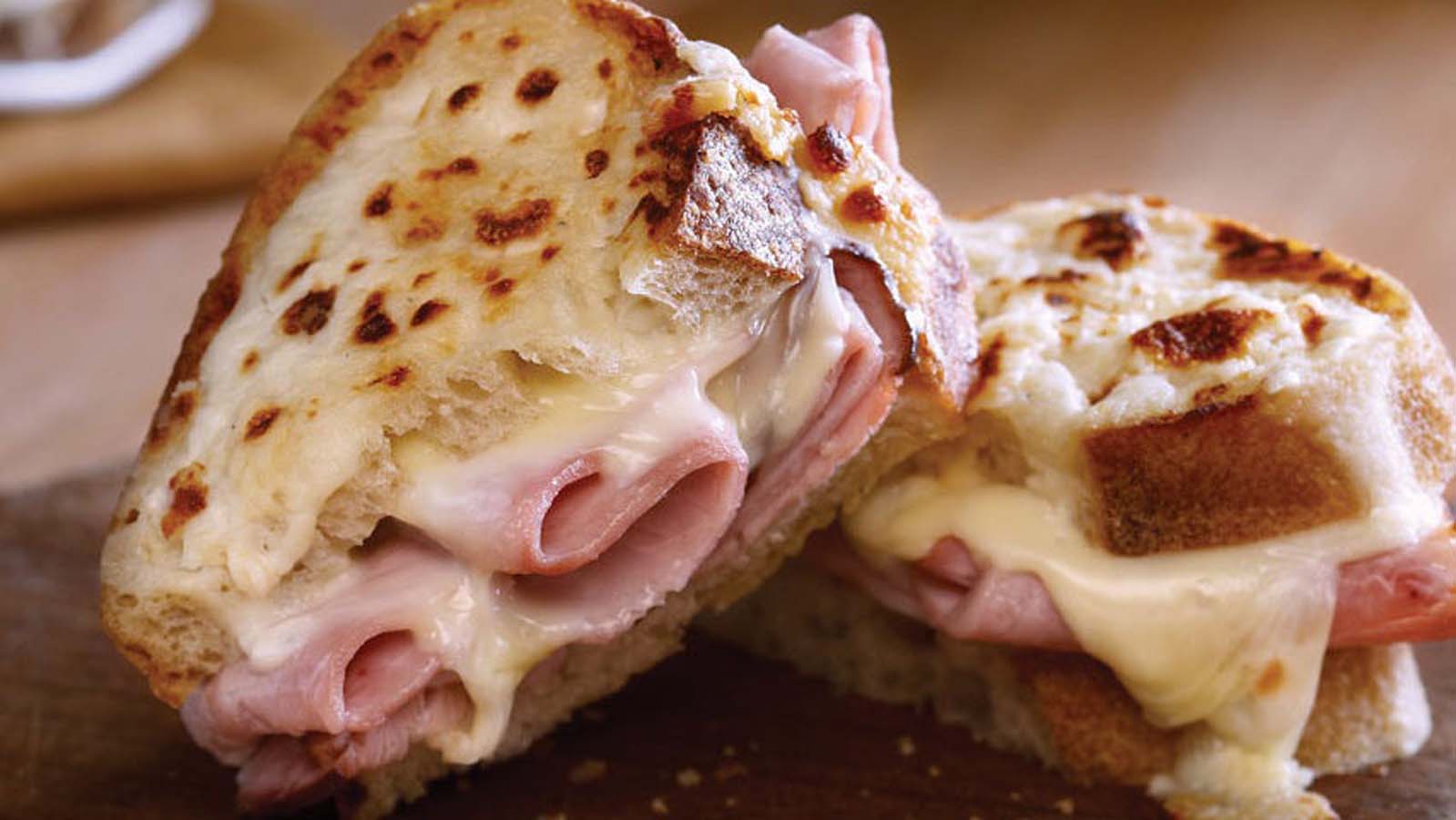 A gourmet grilled Croque Monsieur sandwich with melted gruyere cheese and ham.
