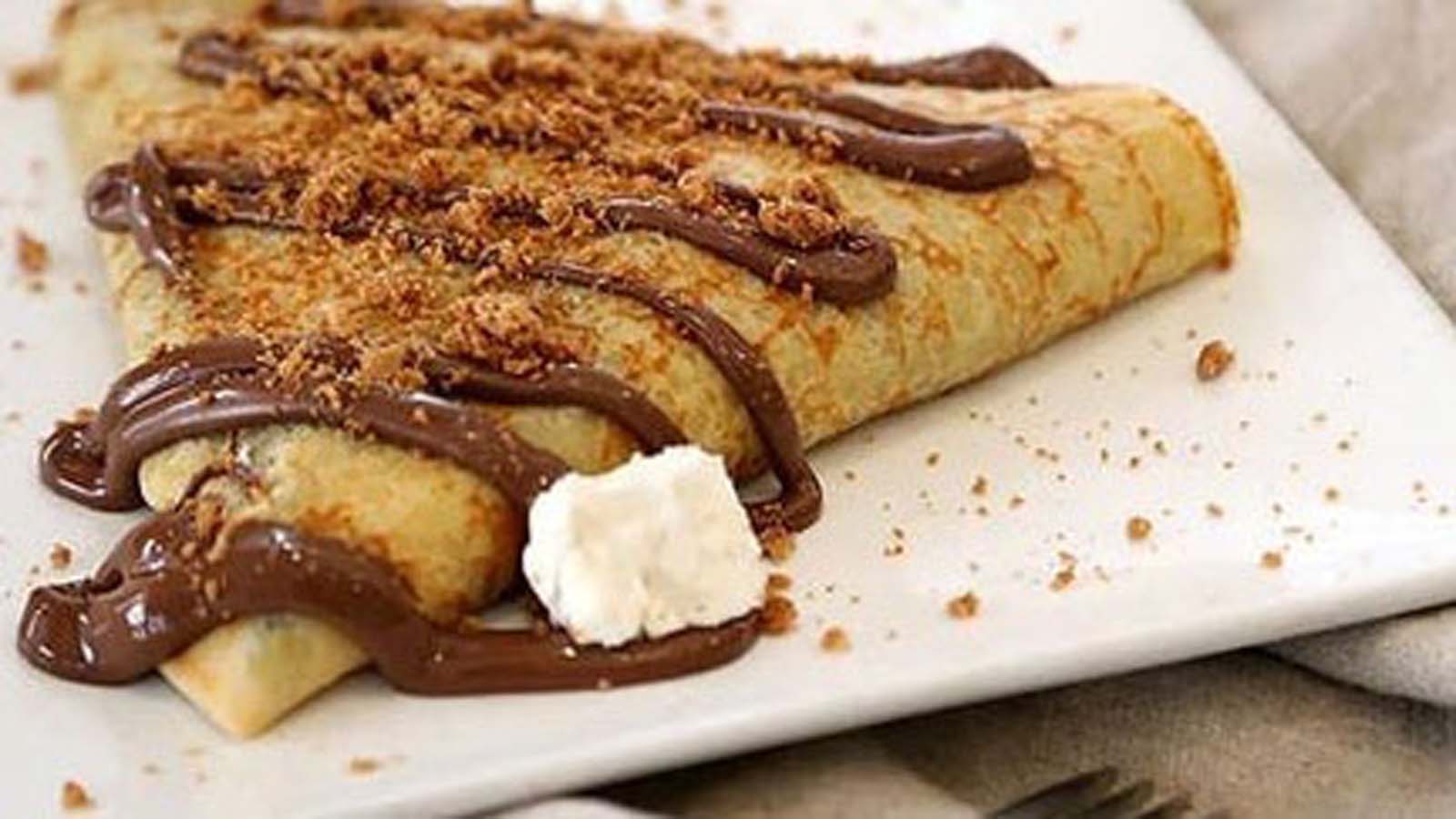 Thin sweet custard pancakes rolled up gently on a serving dish.