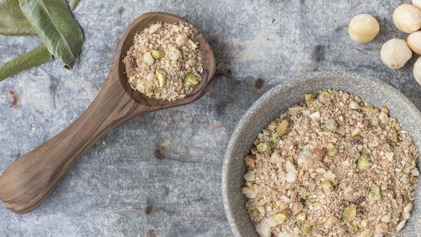 A bowl of crunchy Egyptian Dukkah spice mix containing crushed nuts, seeds, and spices.