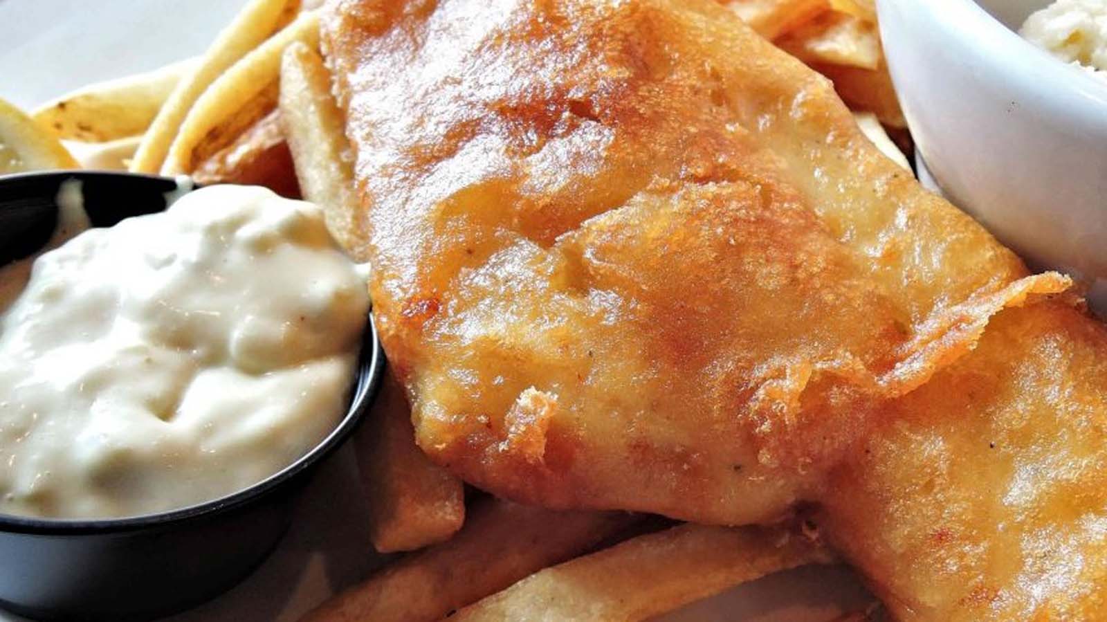 A classic newspaper basket of crispy beer-battered fish and golden potato chips.
