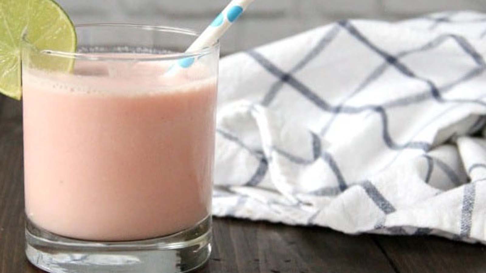 A refreshing pink blended tropical guava smoothie inside a clean glass jar.