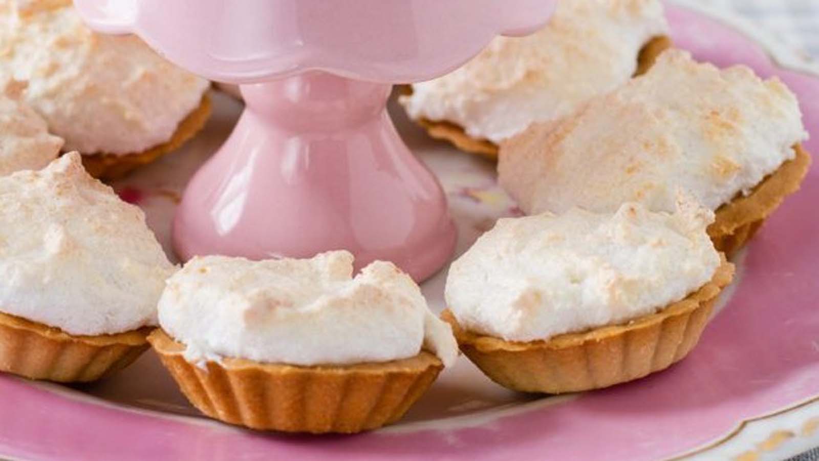 Traditional South African Hertzoggies with a sweet pastry crust, jam filling, and coconut meringue topping.