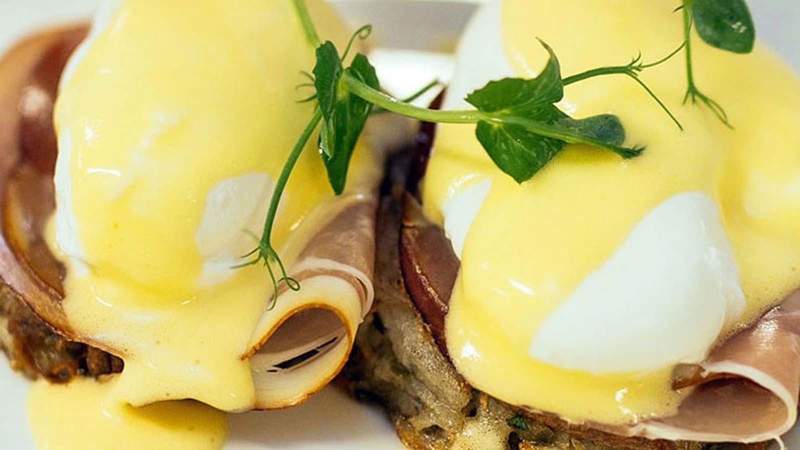 Smooth and velvety yellow homemade Hollandaise sauce served in a small bowl.