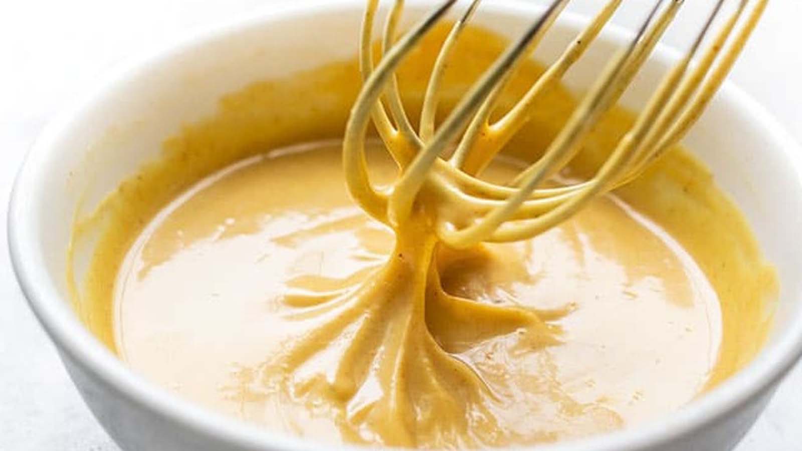 A smooth, creamy yellow honey curry mayonnaise dip sauce inside a ramekin bowl.