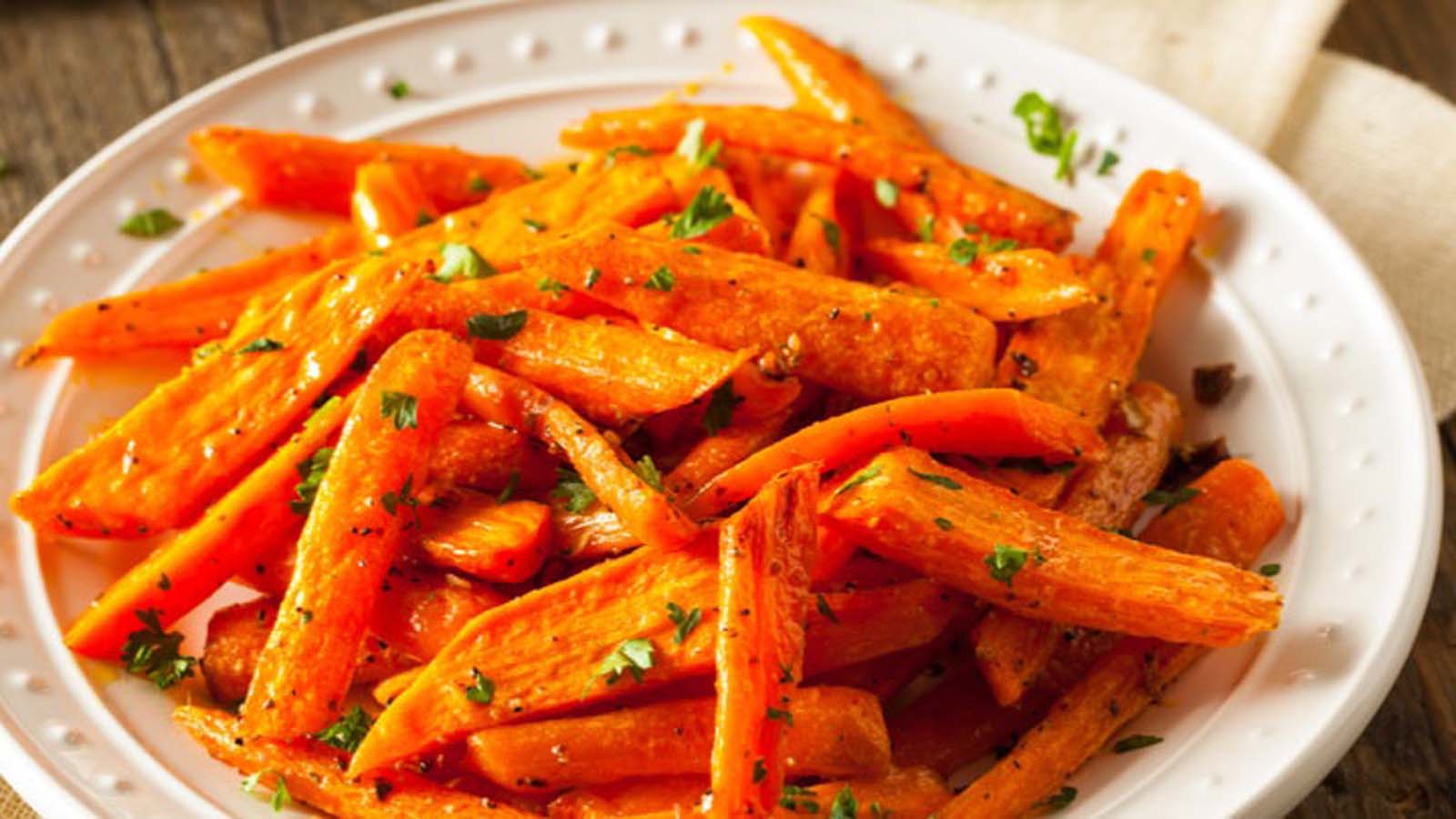A side dish of sweet, glossy honey glazed carrots cut into coins.