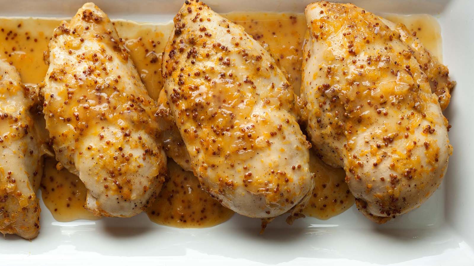 A smooth emulsion of honey mustard salad dressing in a glass bottle container.