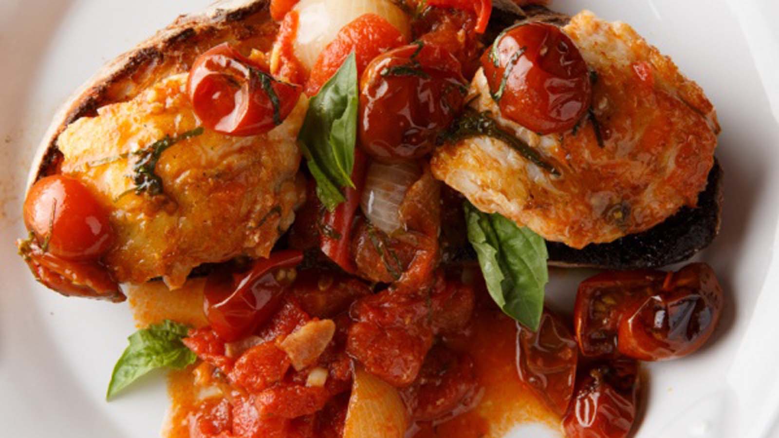Chunks of fresh meaty monkfish fish poached in a robust, spicy tomato herb sauce.