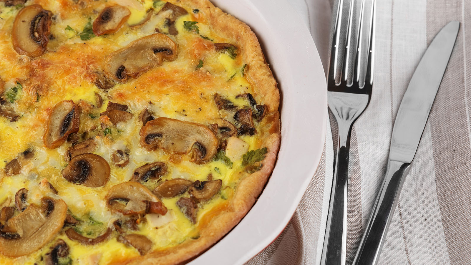 A gourmet omelet combining sautéed mushrooms, wilted spinach leaves, and crumbled feta cheese.