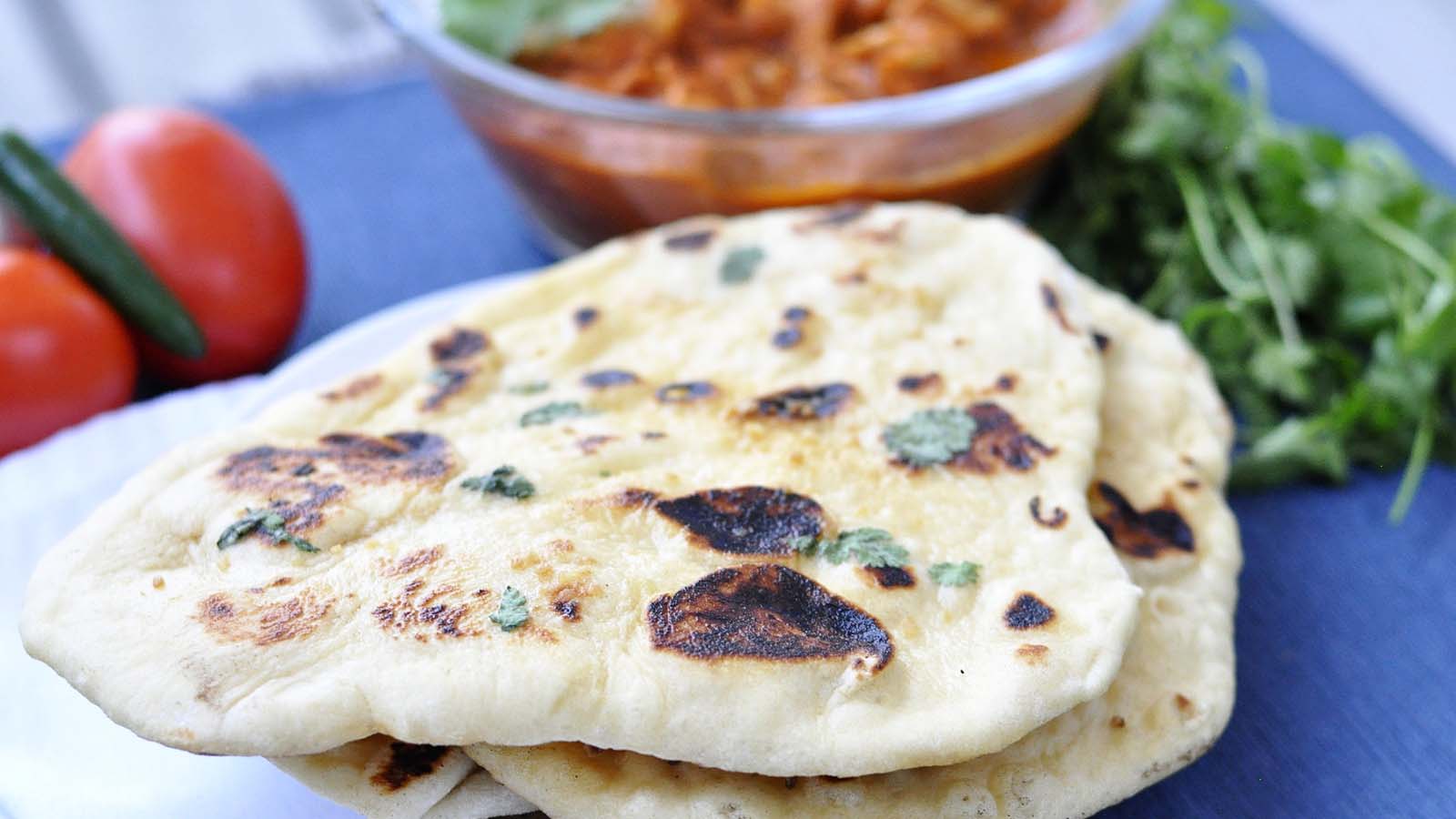 Soft, charred and puffy Indian naan bread fresh from the hot tandoor oven.