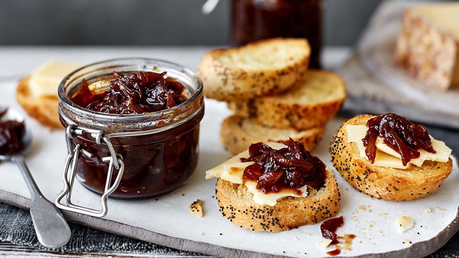 Sweet and tangy dark purple red onion marmalade relish in a glass jar.