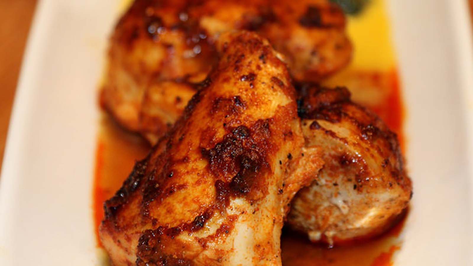 Tender chicken pieces marinating in a red, savoury overnight paprika chicken marinade spice.