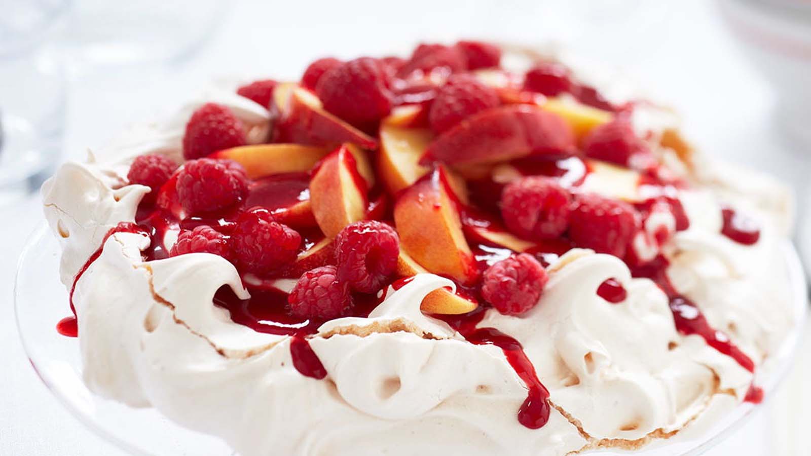 A light and airy crisp pavlova meringue shell topped with whipped cream and fresh fruits.
