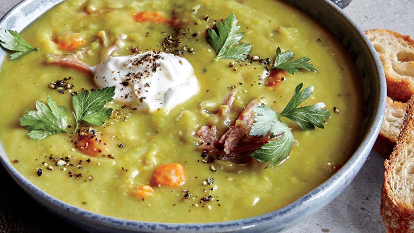 A thick, hearty green pea and ham soup cooked with tender smoked ham hock pieces.
