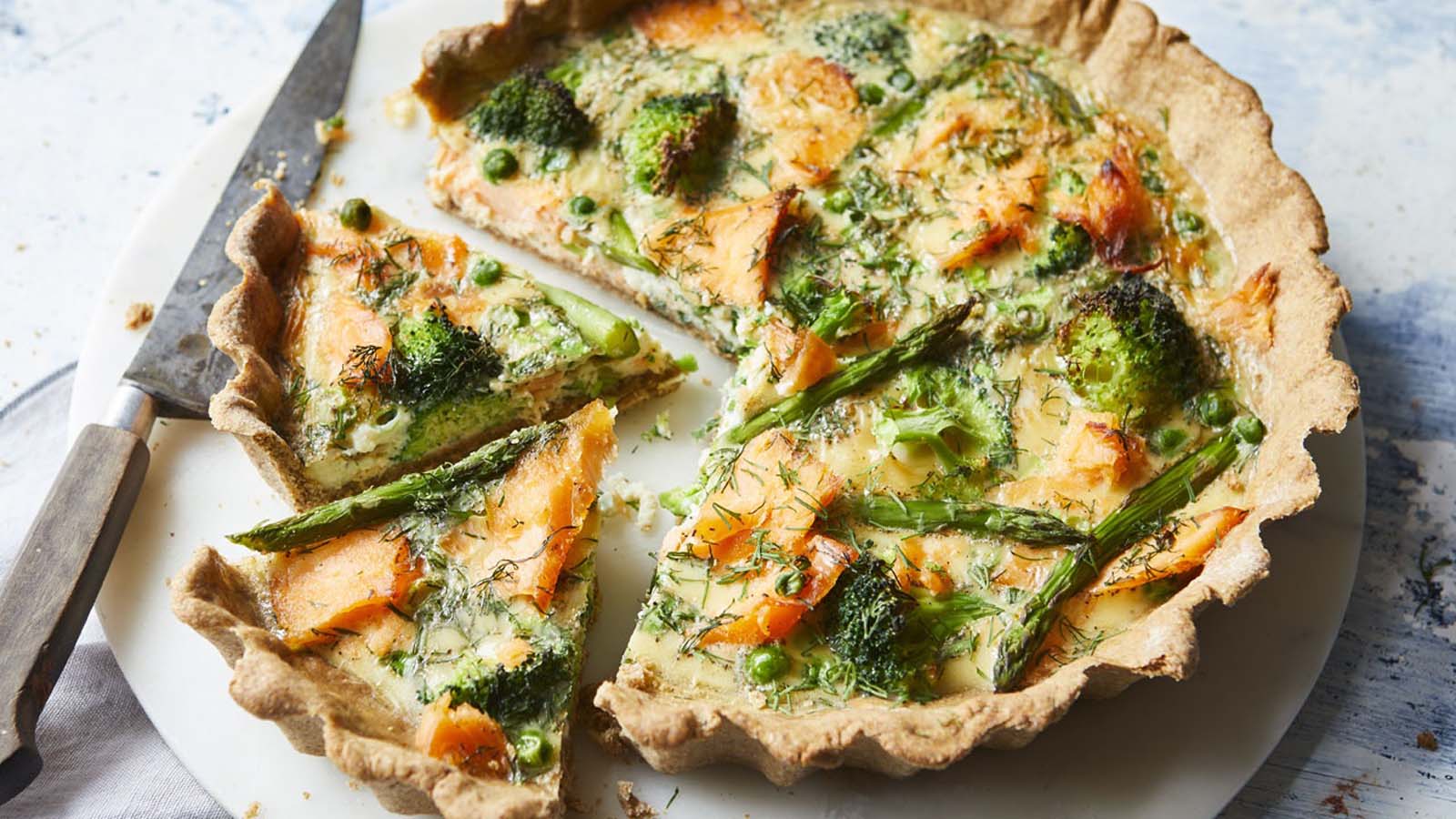 Raw, flaky quiche pastry dough pressed perfectly into a ceramic tart dish.