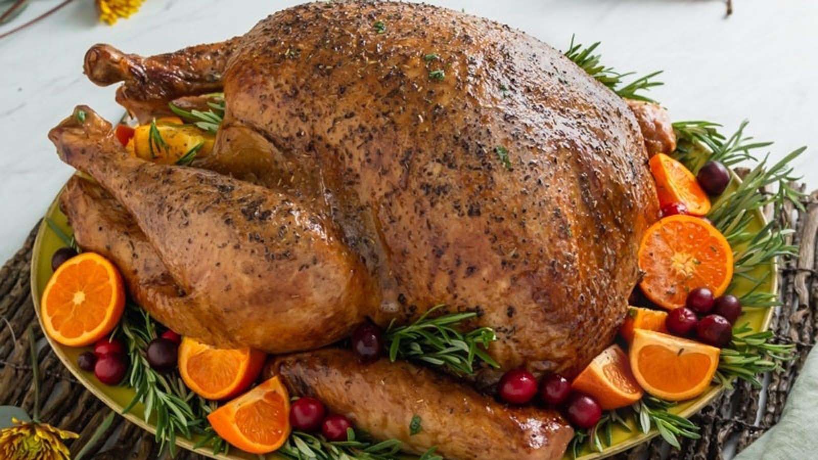 A magnificent whole golden brown roast turkey served on a festive holiday dinner table.