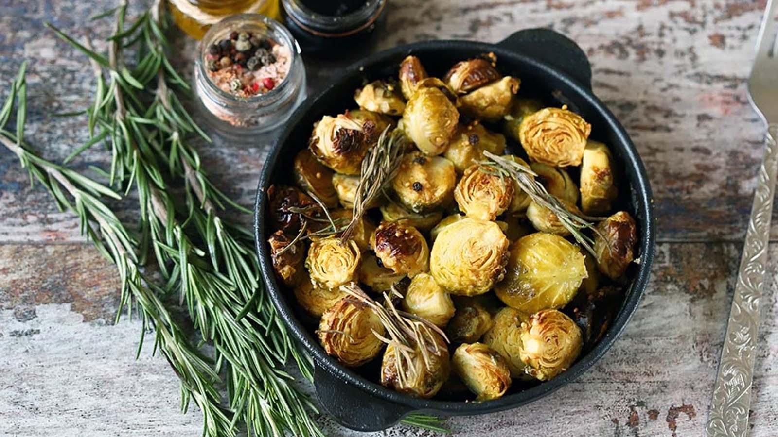 A sheet pan of crispy roasted oven-baked whole Brussels sprouts seasoned with garlic.