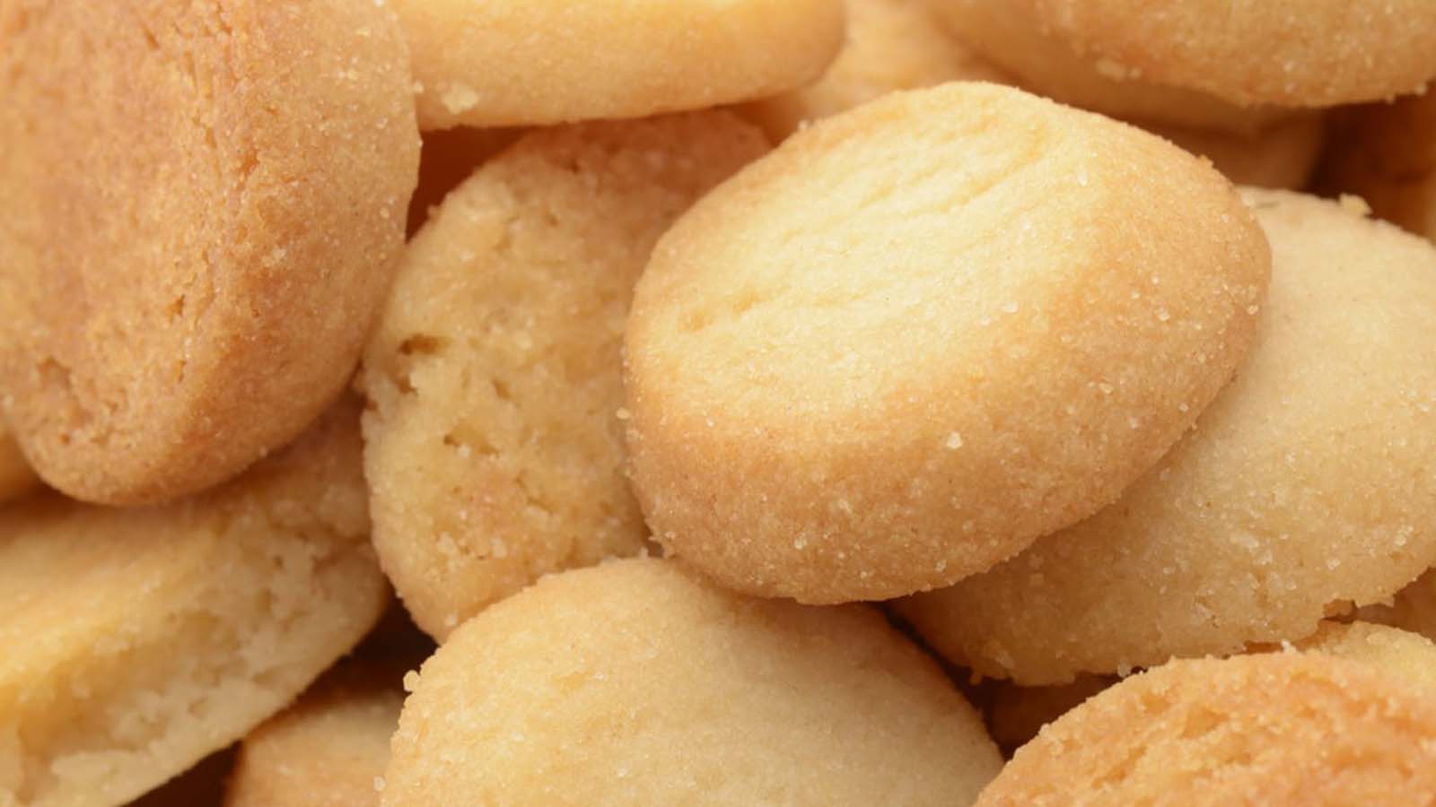 Delicate small shortbread biscuits arranged neatly, showing a light and crumbly texture.