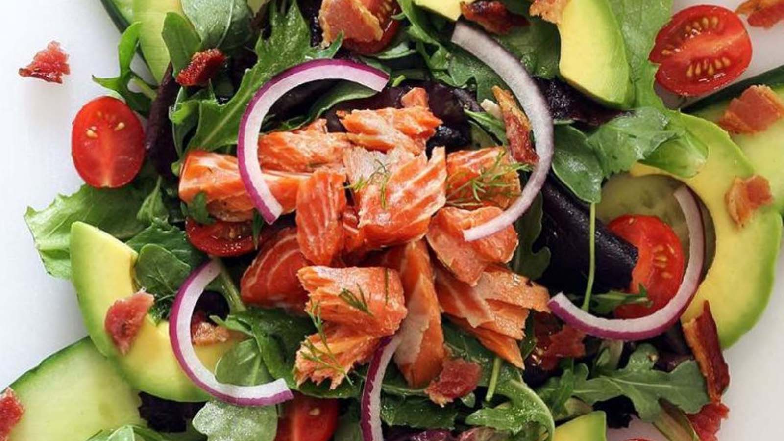 A premium smoked salmon salad with delicate pink salmon ribbons and fresh cucumber.