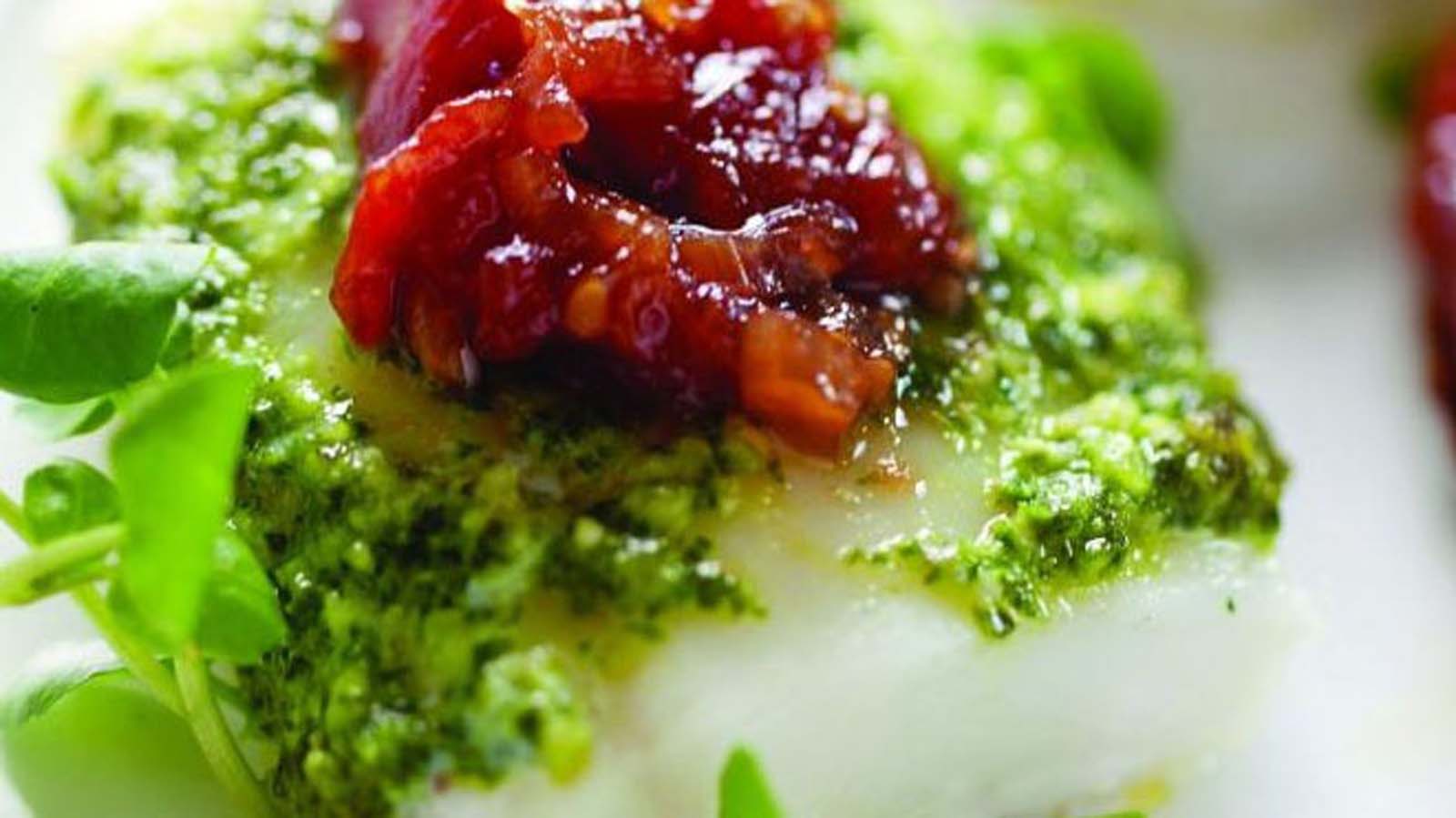 A vibrant red homemade tomato and red chili sauce simmering with herbs.