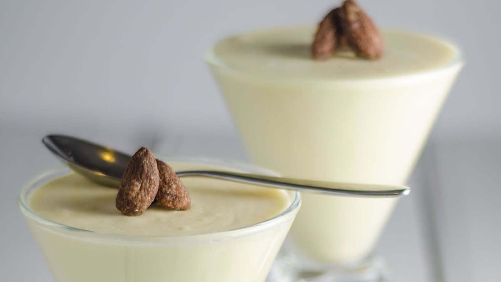 A delicate, airy glass cup filled with sweet white chocolate mousse dessert cream.