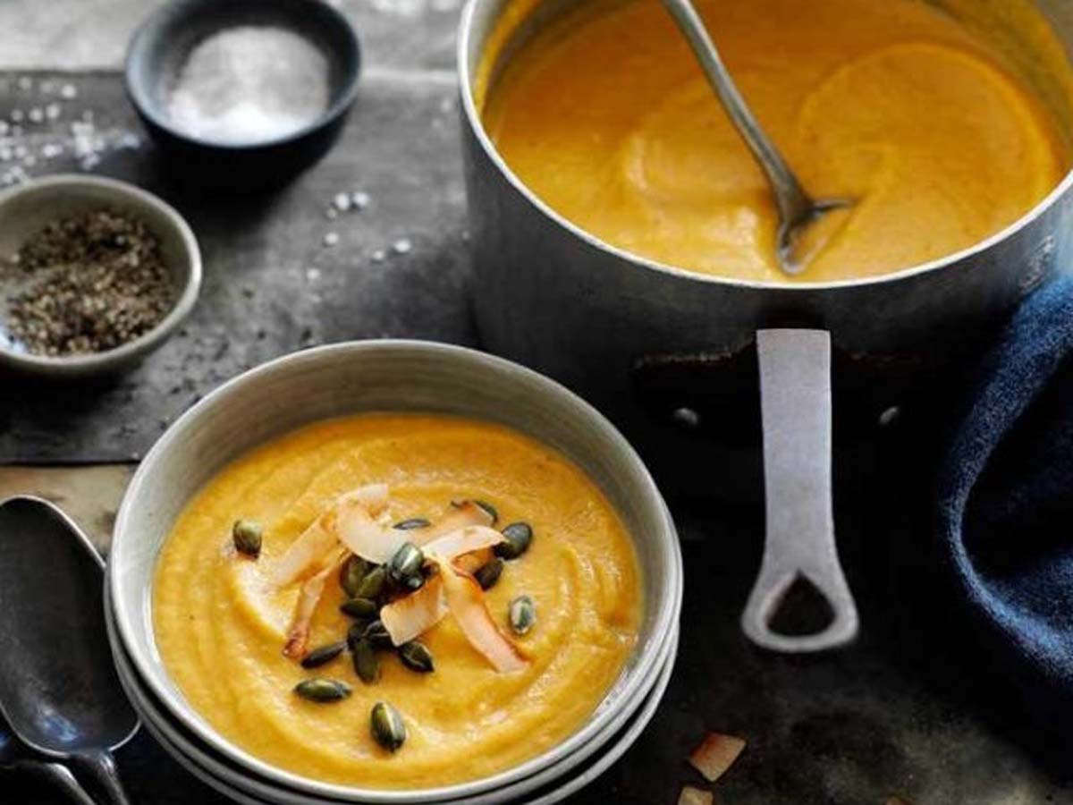 A silky smooth, vibrant orange roasted butternut soup in a ceramic bowl.