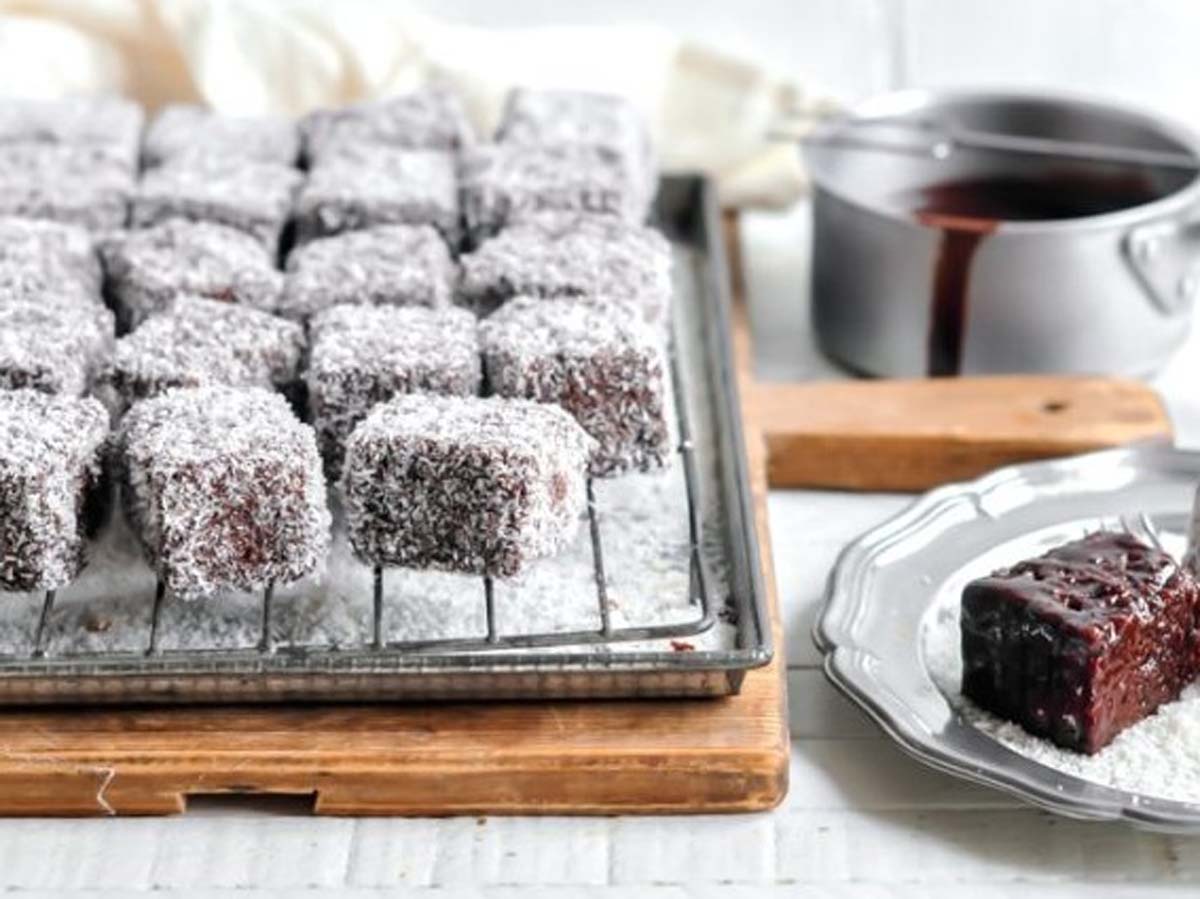 Classic Australian lamington sponge cake cubes coated in chocolate sauce and rolled in coconut flakes.