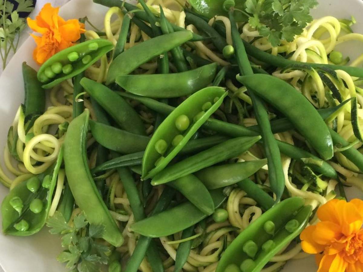 A crisp mixed green salad featuring fresh garden vegetables and a vibrant zesty dressing.