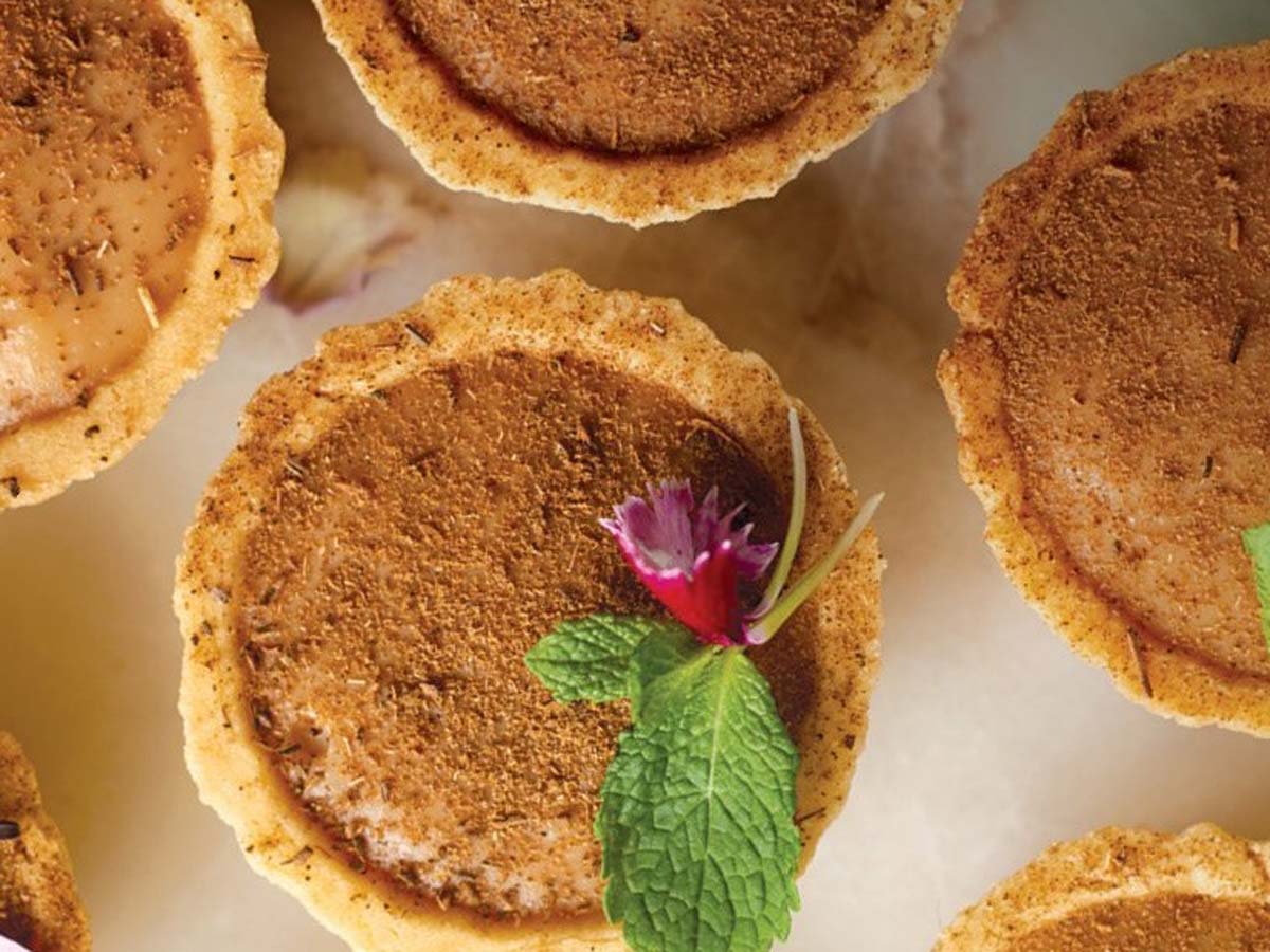 A traditional baked South African milk tart dusted lightly with cinnamon powder.