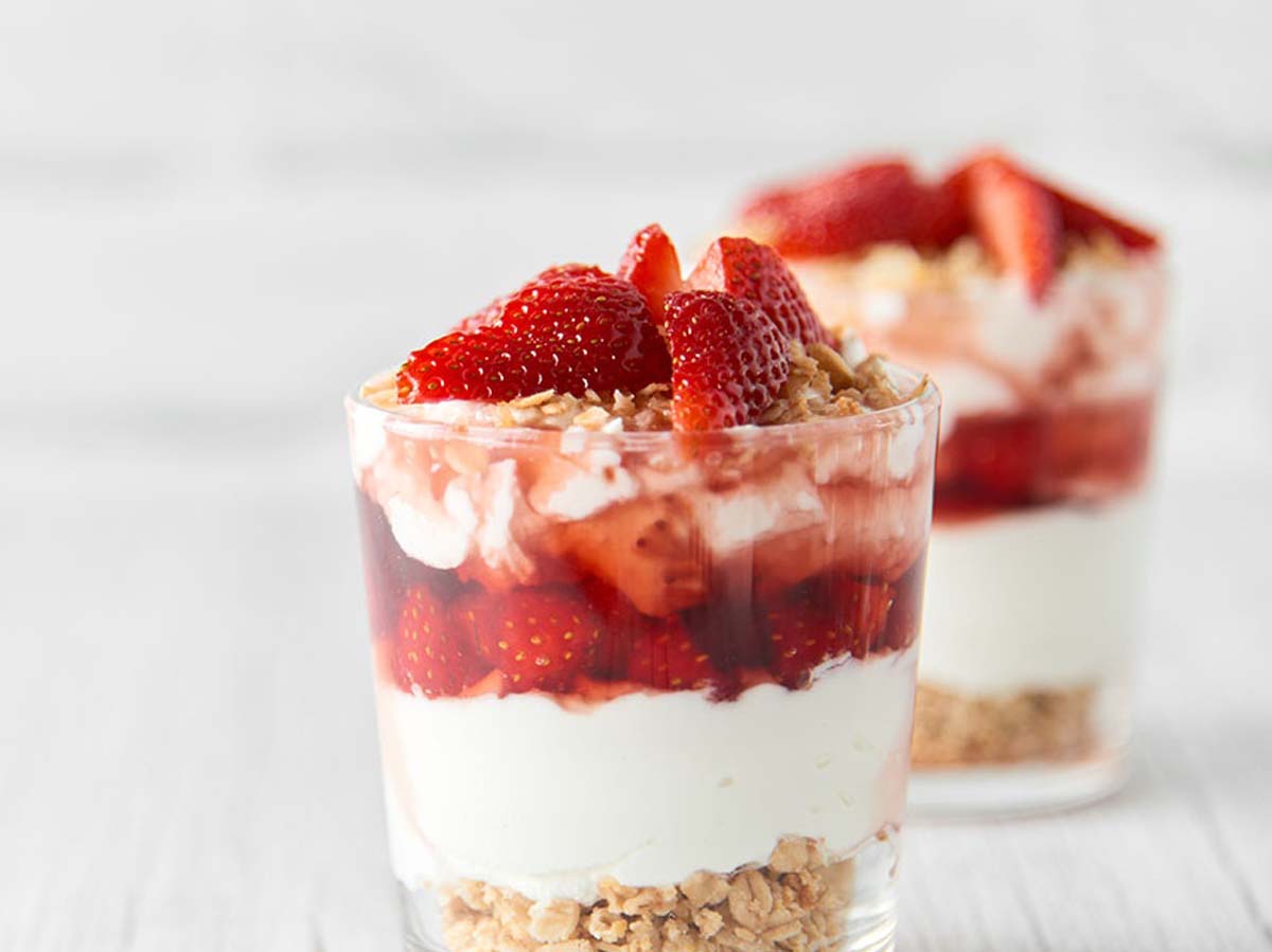 A beautiful layered summer berry Christmas trifle dessert in a large glass bowl.