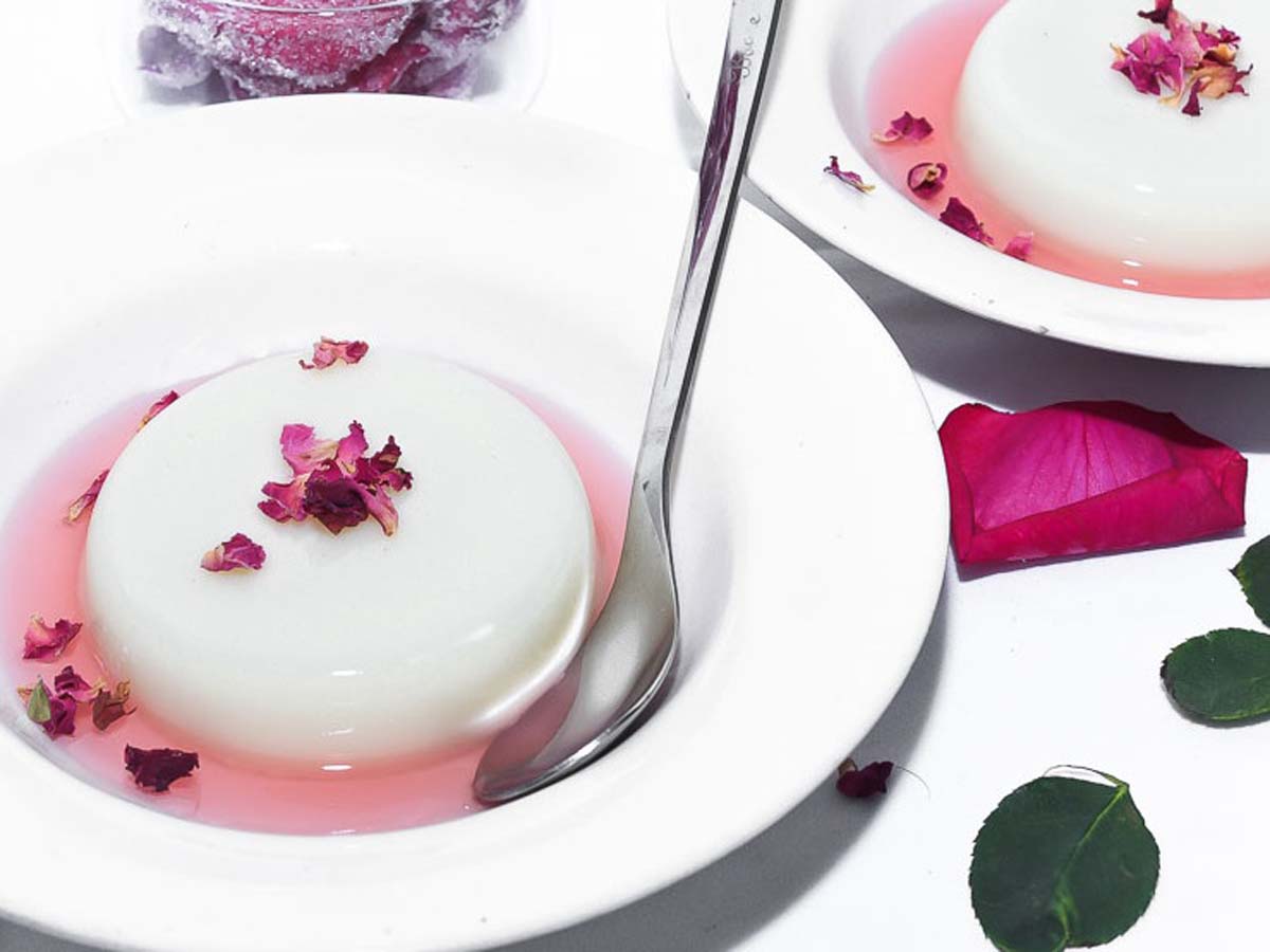 Velvety smooth vanilla panna cotta unmolded on a plate with fresh berry coulis.