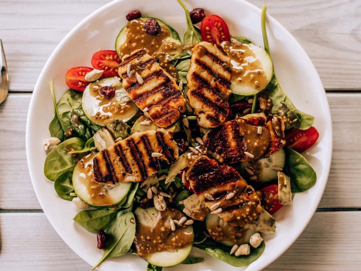 A fresh Cajun chicken salad with sliced spicy grilled chicken over garden greens.