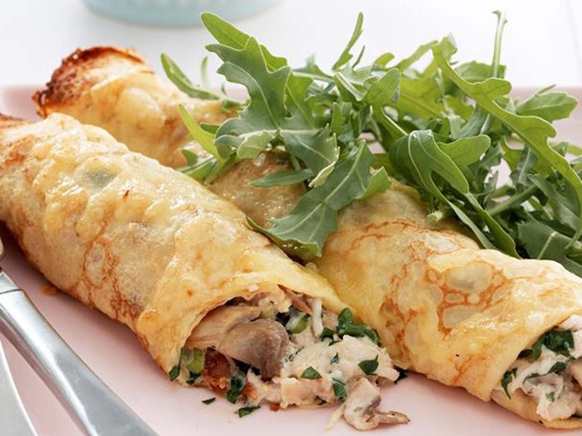 savoury pancakes filled with a creamy chicken mixture and rolled up tightly.