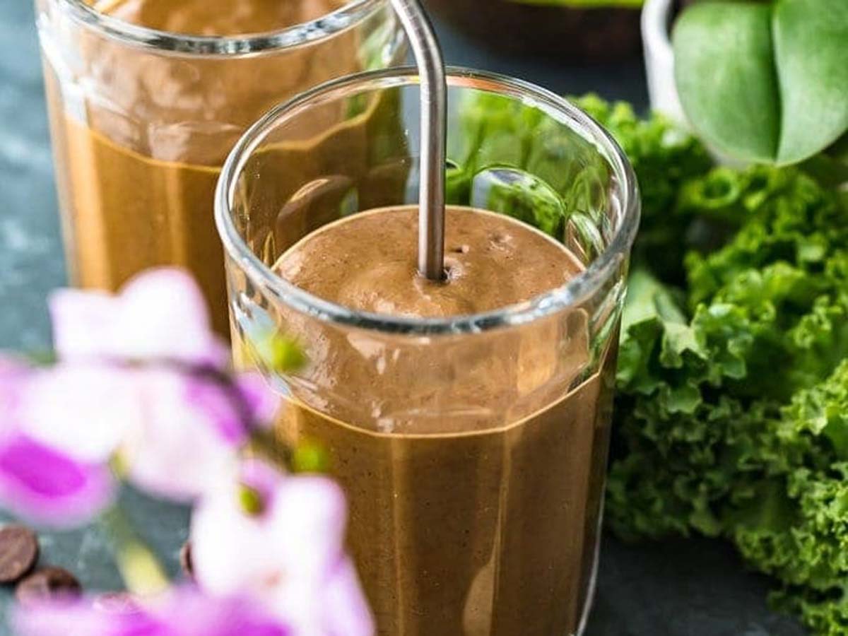 A rich and healthy dark chocolate detox smoothie inside a tall glass straw jar.